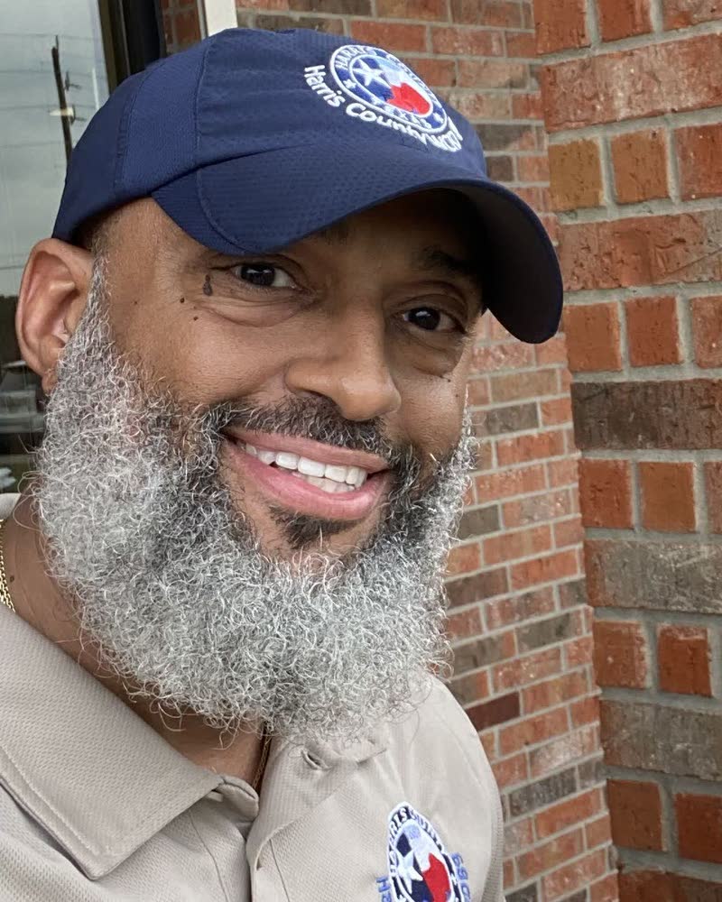 Portrait of Tahir Charles wearing a Harris County WCID 89 cap and polo shirt.