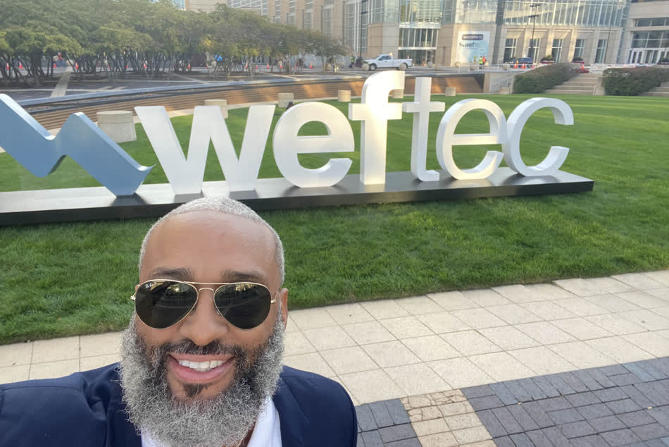 Tahir Charles outside the WEFTEC conference, in front of the large WEFTEC sign.